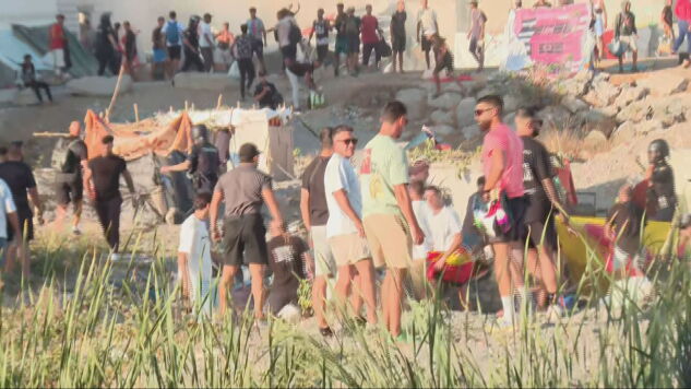 Manifestantes atacan el asentamiento de migrante en la playa de Ben&iacute;tez de Ceuta. 