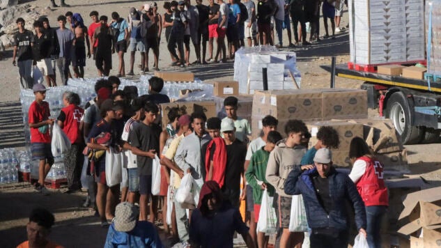 Inicio del reparto de alimentos por parte de miembros de Cruz Roja a los migrantes en la playa del Trampol&iacute;n