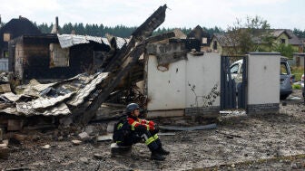 Un rescatista descansa en los escombros de una casa en Kyiv
