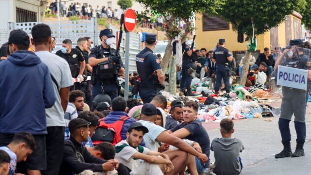 Migrantes frente a la explanada de embotellamiento de Loma Colmenar donde hace casi dos semanas, se habilit&oacute; un campamento temporal para realojar a los migrantes