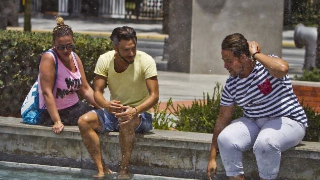 Personas refresc&aacute;ndose en Huelva