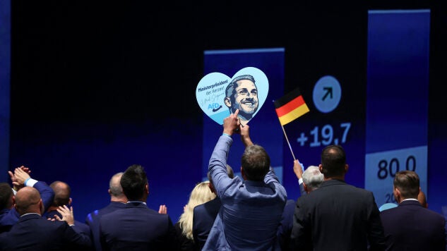 Un simpatizante del partido ultraderechista Alternativa para Alemania ( AfD ) sostiene un cartel con la imagen del principal candidato del AfD , Ulrich Siegmund.