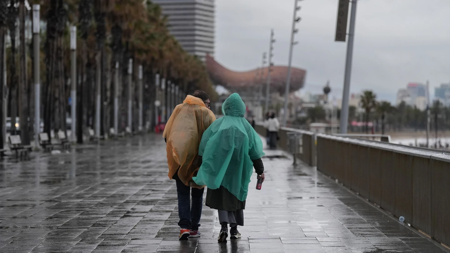 Vecinos de Barcelona pasean bajo la lluvia en una imagen de archivo. Vecinos de Barcelona pasean bajo la lluvia en una imagen de archivo.