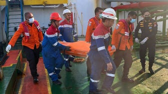 Fotograf&iacute;a cedida por la Agencia Nacional para B&uacute;squeda y Rescate (Basarnas) que muestra a integrantes de equipos de rescate trasladando un cuerpo sin vida este lunes, en el Mar de Java (Indonesia).