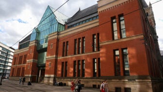 Unas personas pasan frente al Tribunal de la Corona de Minshull Street, en M&aacute;nchester (Reino Unido), mientras 13 hombres son juzgados por delitos sexuales graves contra una misma mujer &mdash;esposa de uno de los acusados&mdash;.