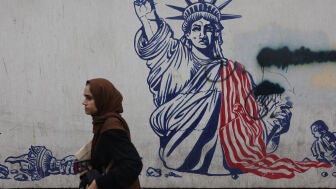 Una mujer, caminando delante de un mural contra Estados Unidos en Teher&aacute;n (Ir&aacute;n)