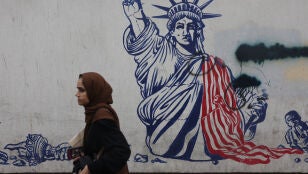 Una mujer, caminando delante de un mural contra Estados Unidos en Teher&aacute;n (Ir&aacute;n)