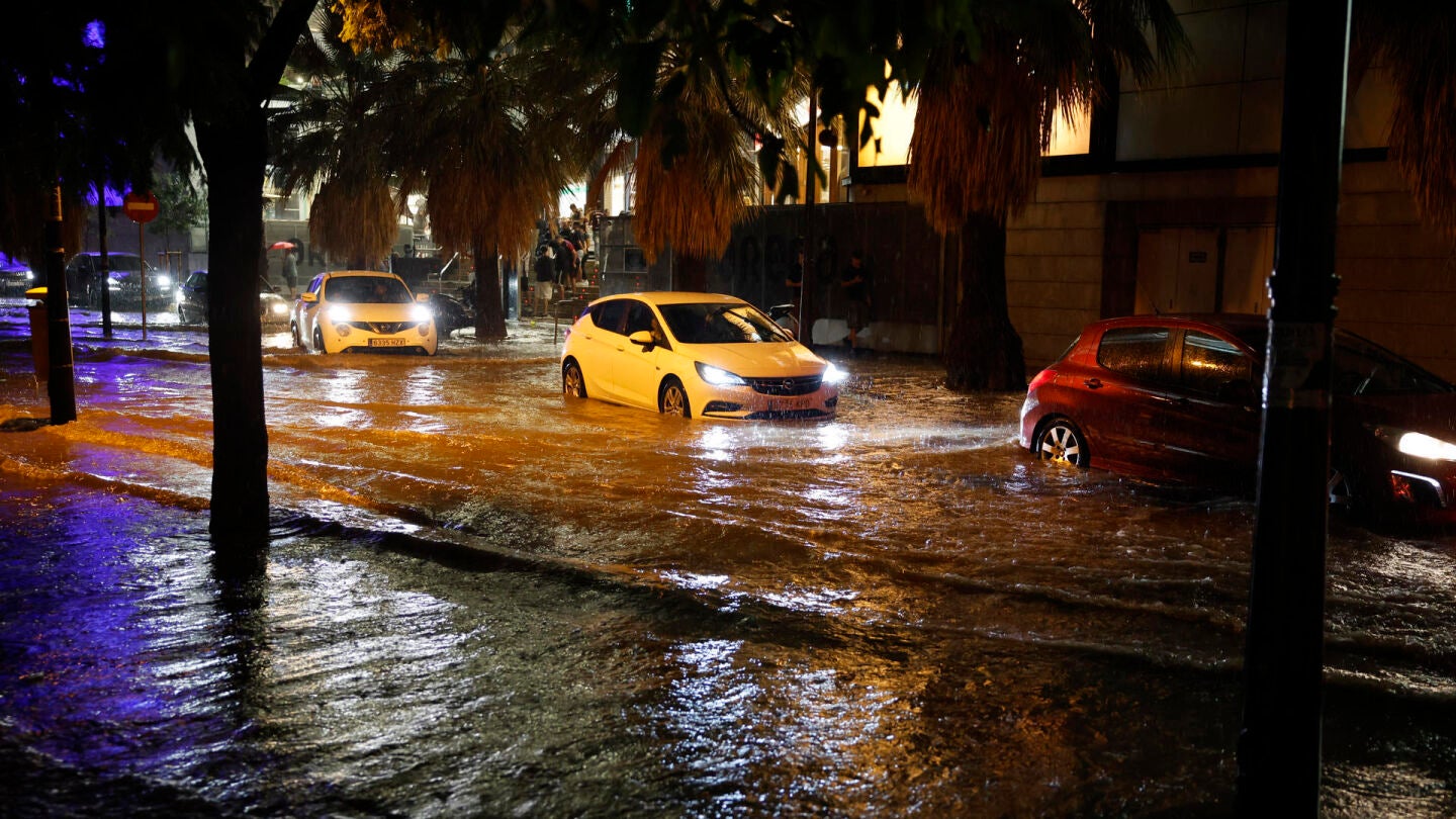 Coches circulan por una calle inundada tras las fuertes lluvias ca&iacute;das en Valencia