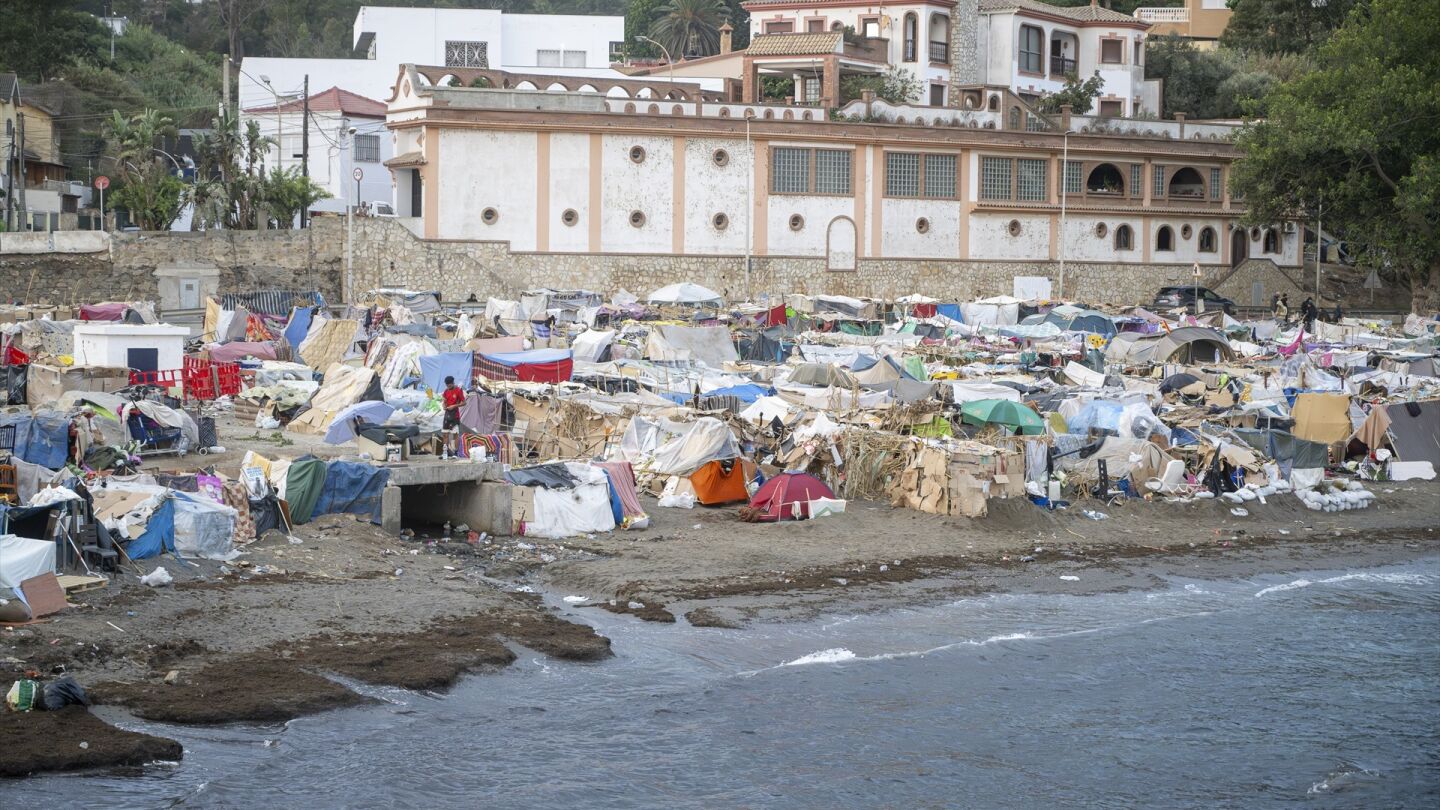 La cara y la cruz de los migrantes en Ceuta: una cama en el puerto frente a quienes siguen durmiendo sobre la arena