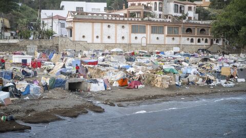 La cara y la cruz de los migrantes en Ceuta: una cama en el puerto frente a quienes siguen durmiendo sobre la arena