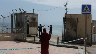 Un guardia civil junto a un migrante en la frontera del Tarajal (Ceuta), entre Marruecos y Espa&ntilde;a