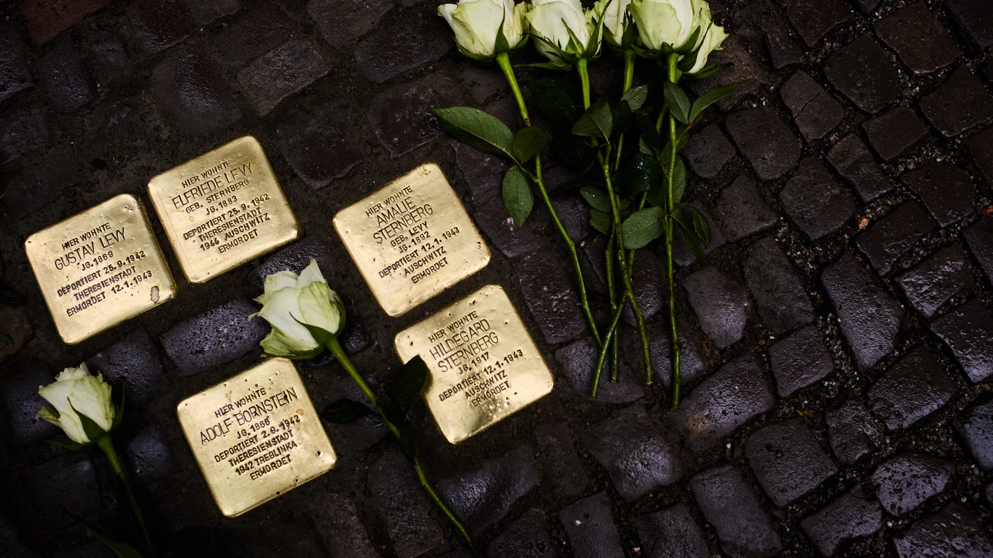 Unas flores yacen junto a placas dedicadas a víctimas del régimen nazi y conocidas como 'stolpersteine'. Unas flores yacen junto a placas dedicadas a víctimas del régimen nazi y conocidas como 'stolpersteine'.
