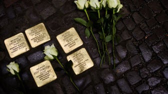 Unas flores yacen junto a placas dedicadas a v&iacute;ctimas del r&eacute;gimen nazi y conocidas como 'stolpersteine'.