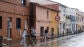 Varios vecinos, quitando el agua de las aceras