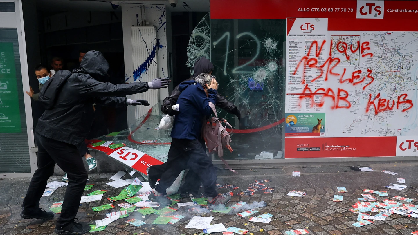 Varias personas salen por el escaparate roto de una tienda para evacuar el edificio, durante los enfrentamientos posteriores a una manifestación en París Varias personas salen por el escaparate roto de una tienda para evacuar el edificio, durante los enfrentamientos posteriores a una manifestación en París
