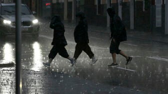Varias personas caminan empapadas por una calle de Palma este lunes.