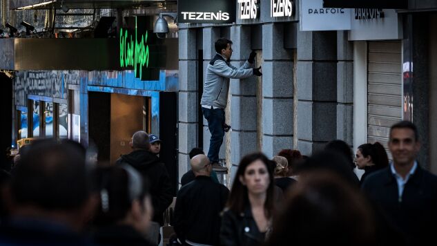 Una persona tapia una tienda en Madrid. 