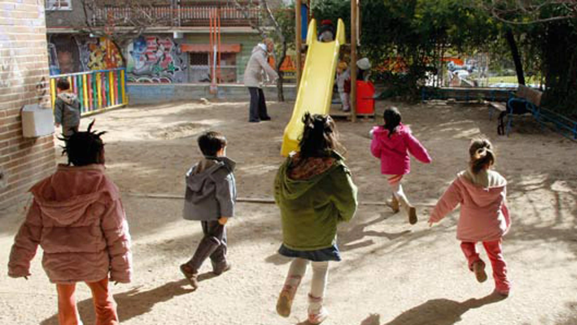 Varios niños salen a jugar a un parque infantil