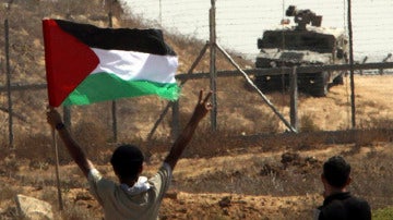 Ondea una bandera palestina ante las tropas israelíes