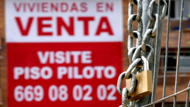 Un cartel anunciador de venta pisos cuelga de una fachada de una nueva promoción en Madrid