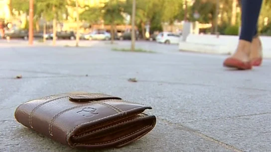 Una cartera perdida en el suelo de un parque Una cartera perdida en el suelo de un parque