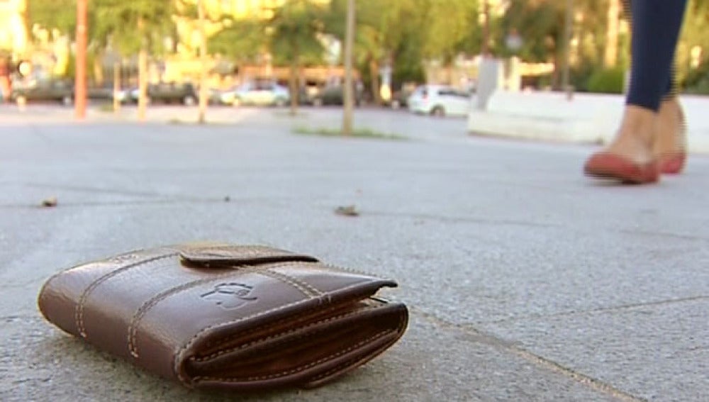 Una cartera perdida en el suelo de un parque