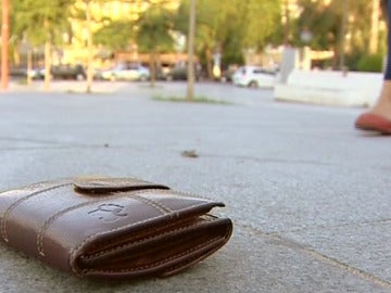 Una cartera perdida en el suelo de un parque Una cartera perdida en el suelo de un parque
