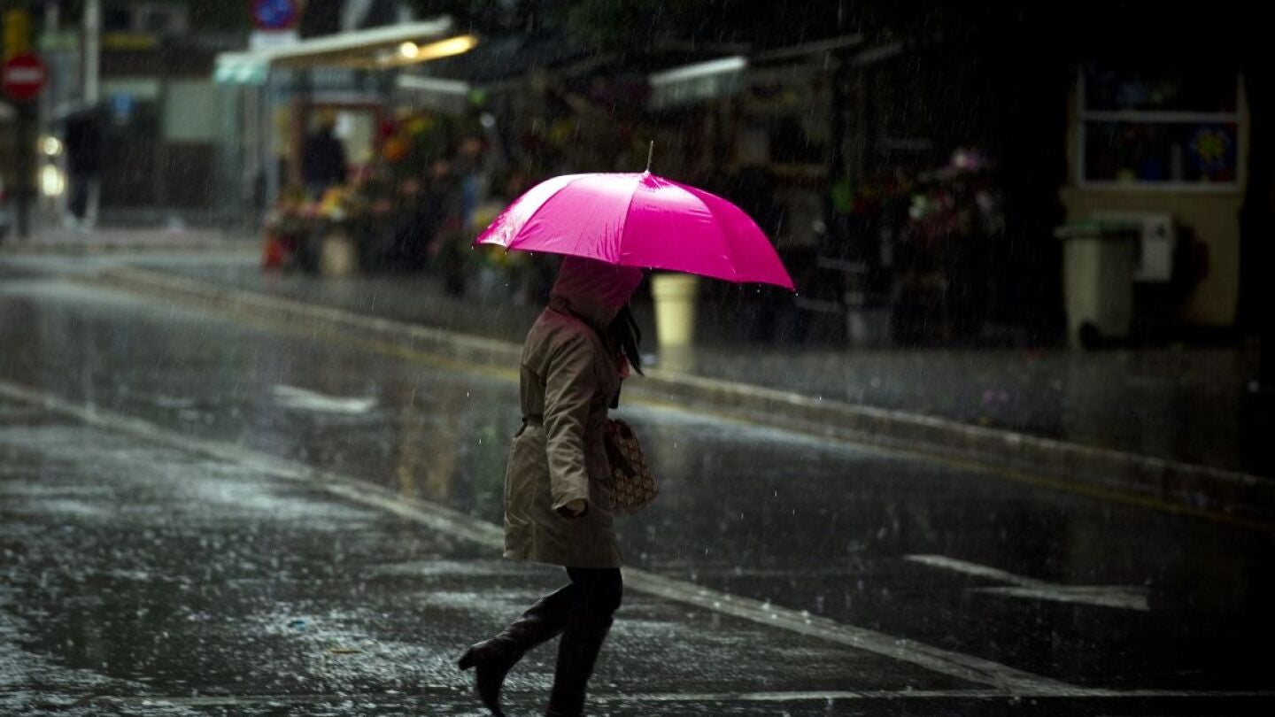 Una malague&ntilde;a se protege de la lluvia con su paraguas