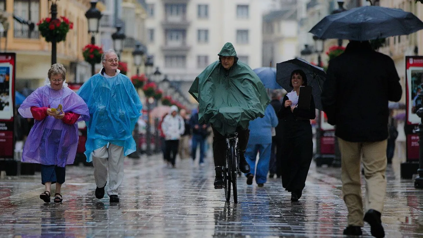 Los viandantes se resguardan de la lluvia Los viandantes se resguardan de la lluvia