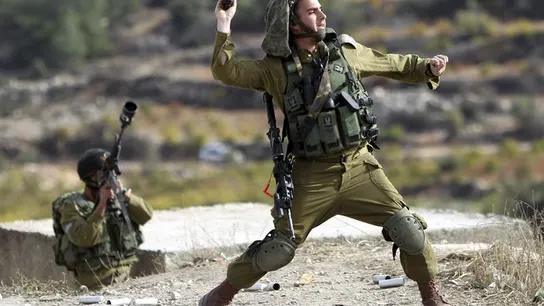 Soldado israelí lanza una granada de aturdimiento a los manifestantes palestinos en Bet Omar Soldado israelí lanza una granada de aturdimiento a los manifestantes palestinos en Bet Omar