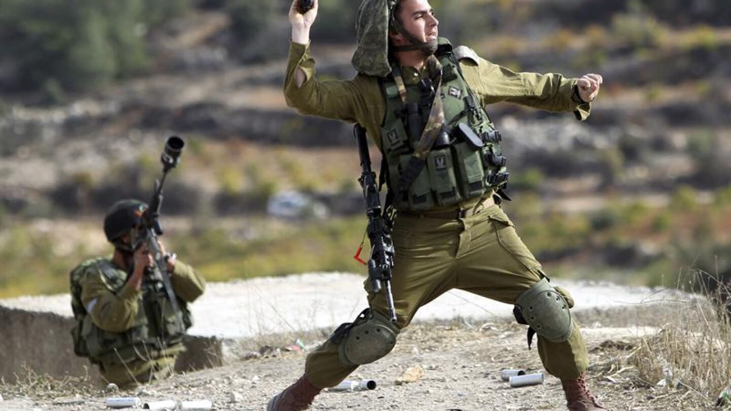 Soldado israel&iacute; lanza una granada de aturdimiento a los manifestantes palestinos en Bet Omar