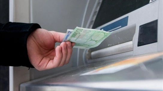 Un hombre saca euros de un cajero automático Un hombre saca euros de un cajero automático