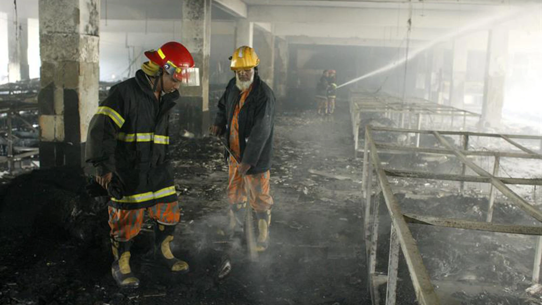 Trabajos de los bomberos en  el incendio de una fábrica textil en Bangladesh