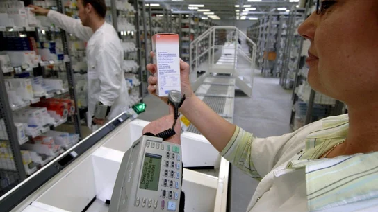 Una farmacéutica escanea el código de barras de un medicamento Una farmacéutica escanea el código de barras de un medicamento