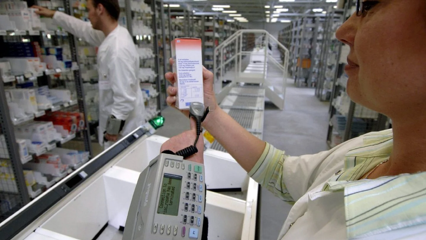 Una farmacéutica escanea el código de barras de un medicamento Una farmacéutica escanea el código de barras de un medicamento