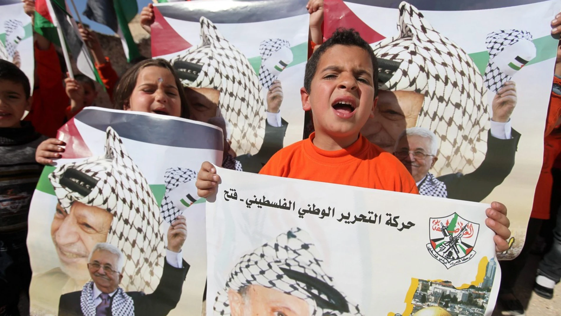 Niños palestinos con los retratos de Mahmoud Abbas y Yasser Arafat
