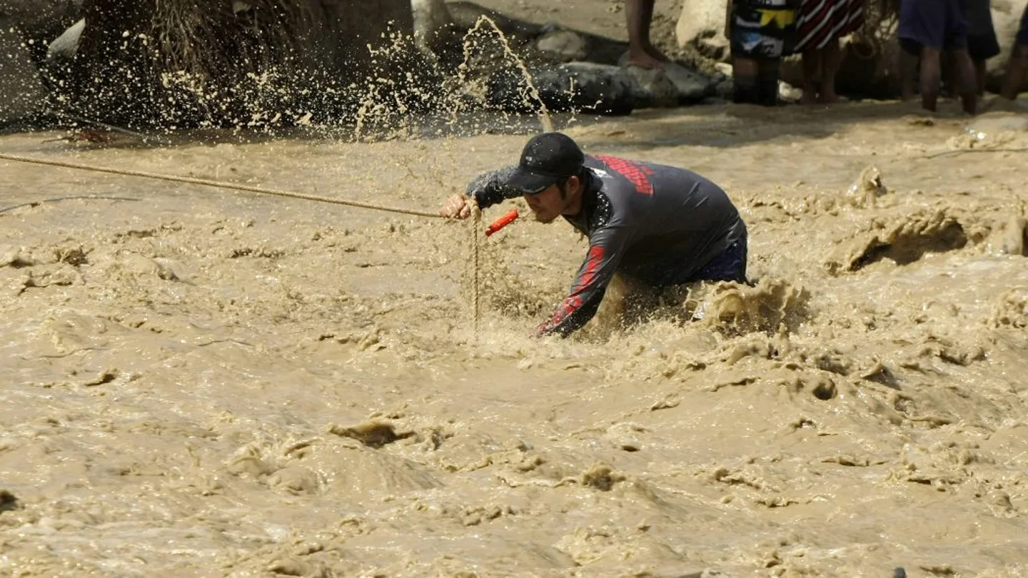 Un miembro de los equipos de rescate en un río desbordado Un miembro de los equipos de rescate en un río desbordado