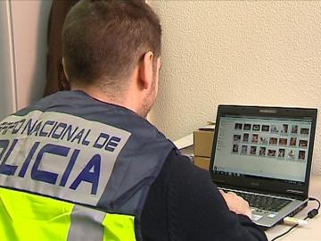 Un policía comprueba archivos en un ordenador Un policía comprueba archivos en un ordenador