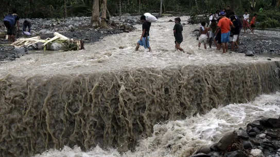 Filipinos cruzan una carretera tras el paso del tifón Filipinos cruzan una carretera tras el paso del tifón