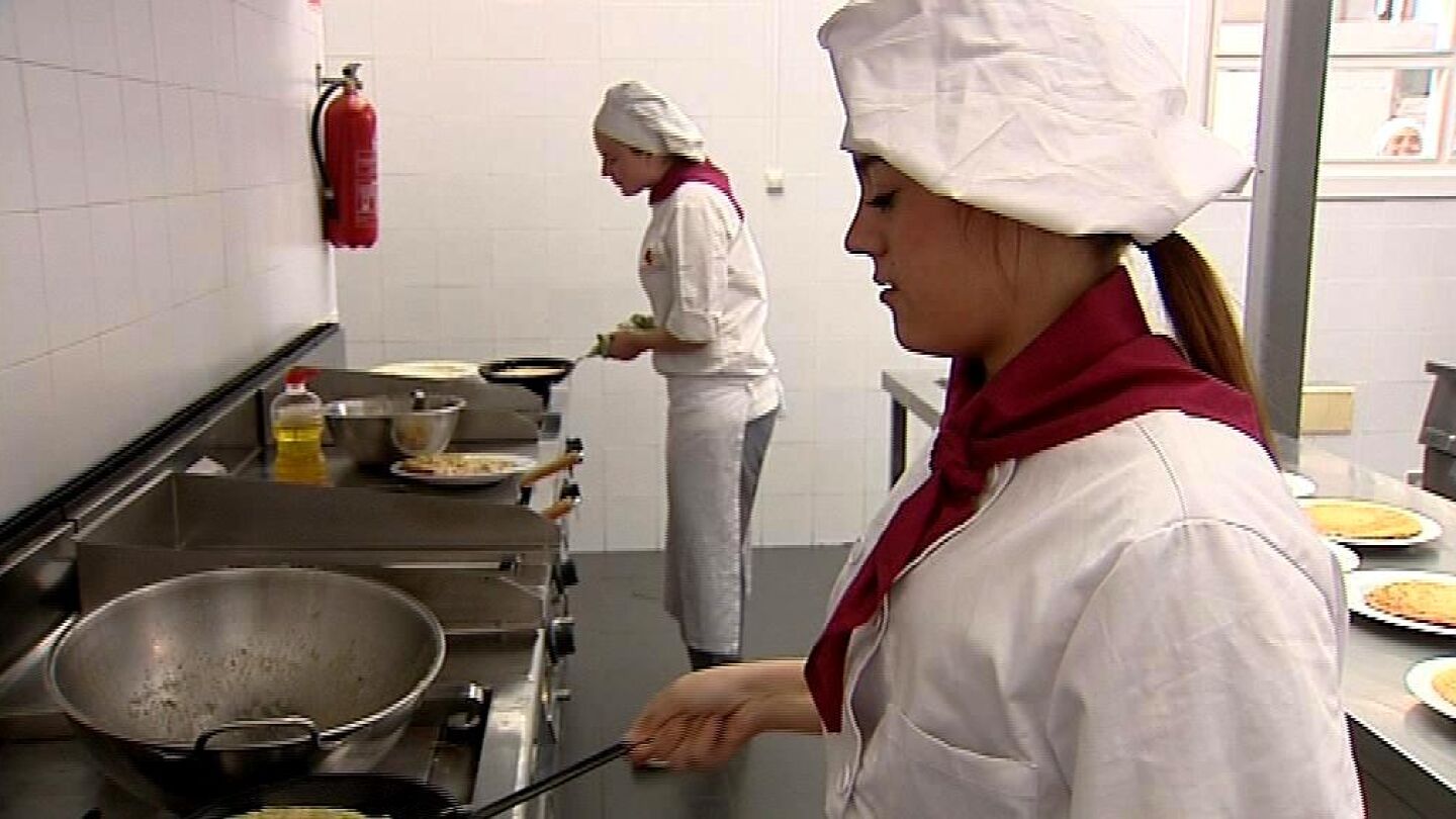 Dos j&oacute;venes aprenden a cocinar -Archivo-