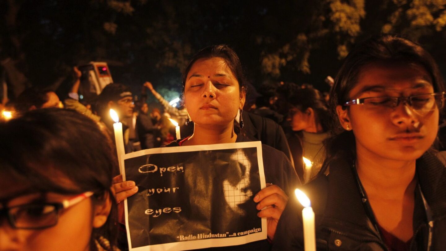 Unos manifestantes sujetan pancartas y velas para protestar