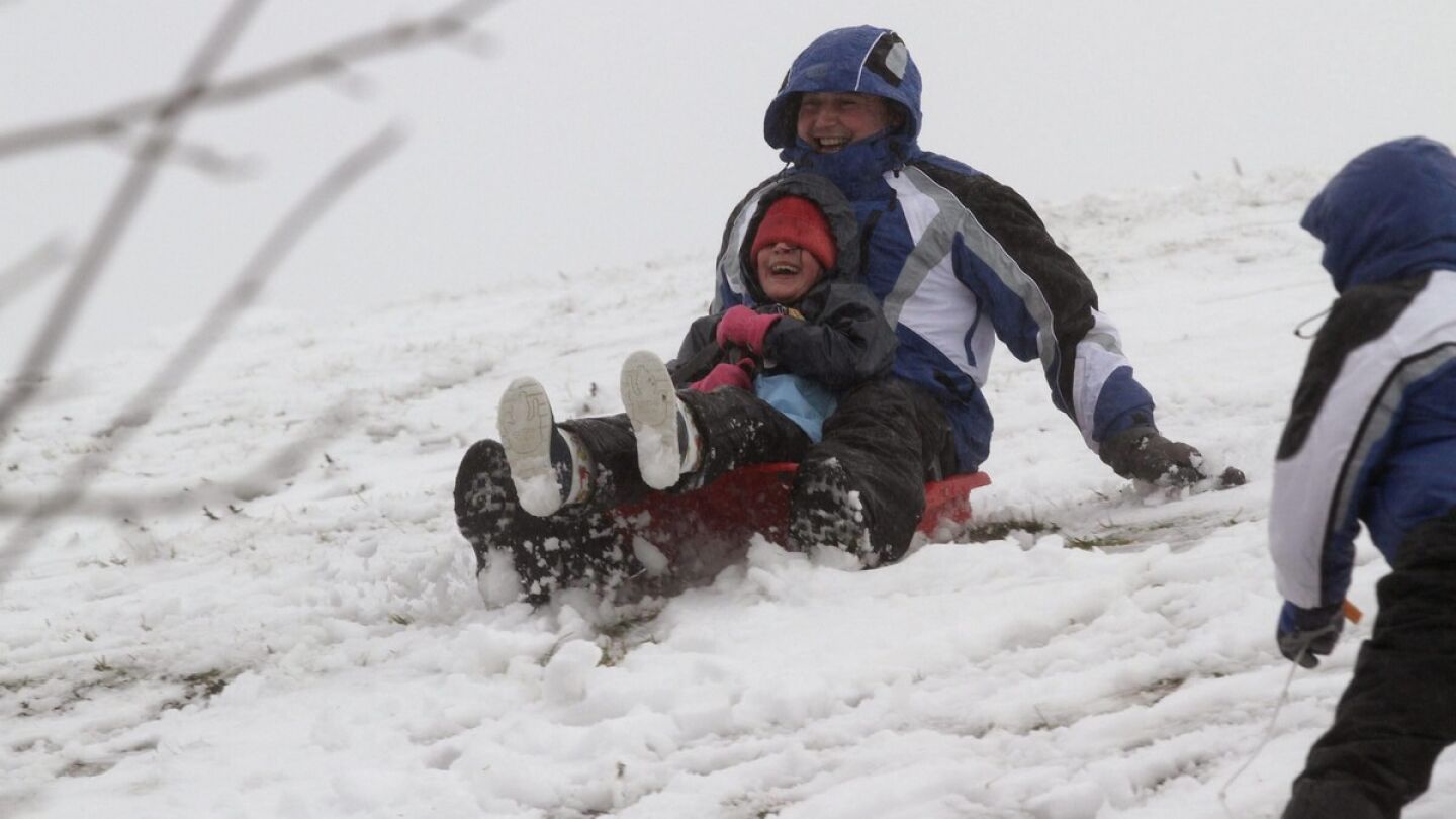 Un hombre y un ni&ntilde;o disfrutan de la nieve en la localidad lucense de O Cebreiro.