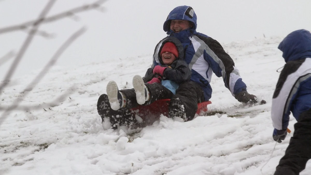 Un hombre y un niño disfrutan de la nieve en la localidad lucense de O Cebreiro.