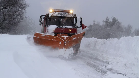 Un camión quitanieves retira la nieve acumulada en una carretera. Un camión quitanieves retira la nieve acumulada en una carretera.