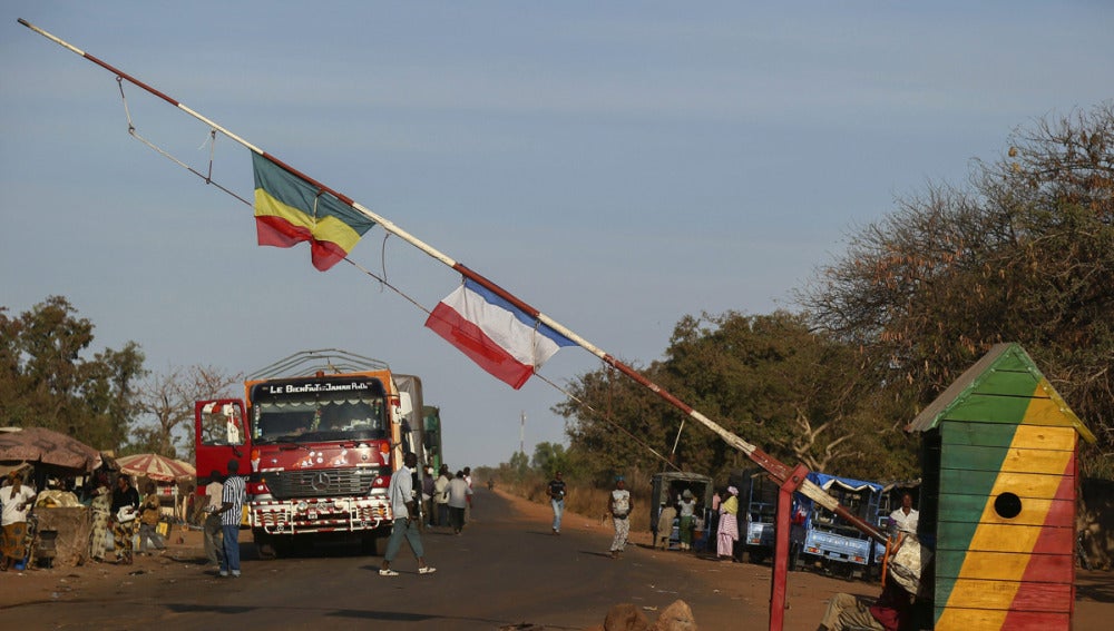 Una bandera de Francia y otra de Mali en la barrera de un punto de registro en Mali.