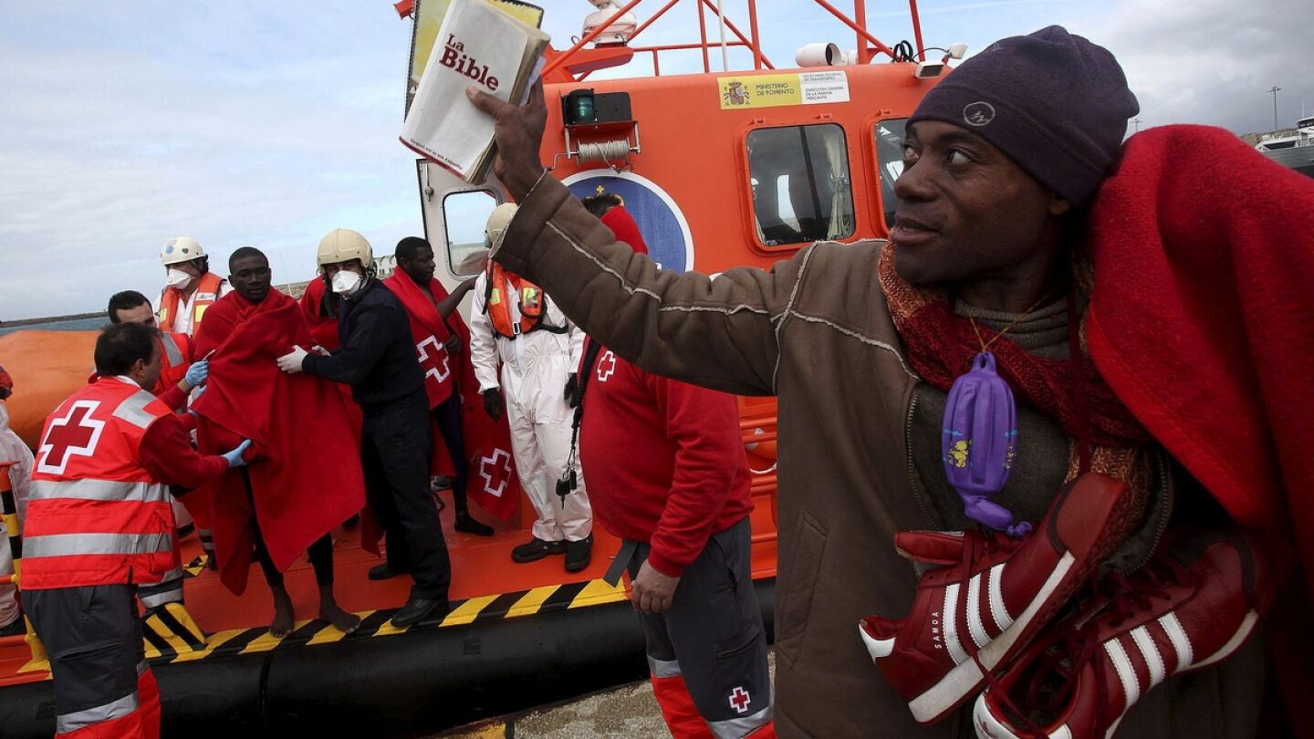 Uno de los inmigrantes muestra una Biblia al llegar ayer a tierra, en C&aacute;diz.