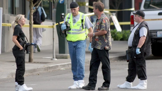 Investigadores de la policía trabajan frente a la entrada de un edificio Investigadores de la policía trabajan frente a la entrada de un edificio