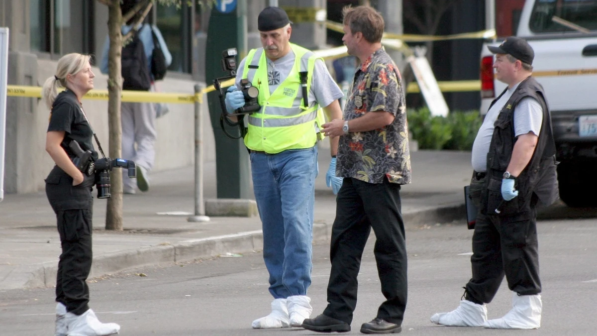 Investigadores de la policía trabajan frente a la entrada de un edificio Investigadores de la policía trabajan frente a la entrada de un edificio