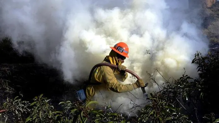 Un bombero apaga el fuego en California