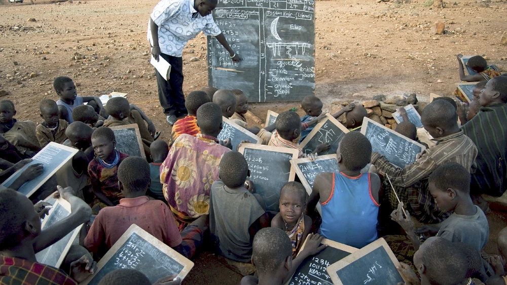 Un profesor da clases a varios alumnos en Karamoja (Uganda). Un profesor da clases a varios alumnos en Karamoja (Uganda).